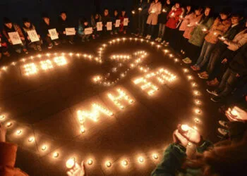 College students light up candles as they pray for passengers of the missing Malaysia Airlines MH370 plane in Yangzhou. (Reuters)