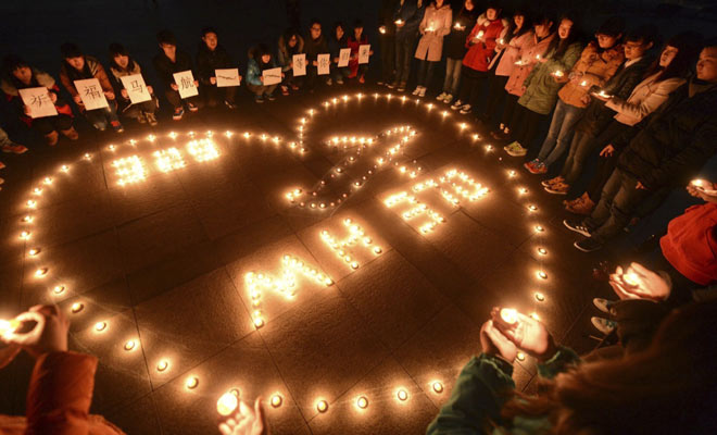 College students light up candles as they pray for passengers of the missing Malaysia Airlines MH370 plane in Yangzhou. (Reuters)