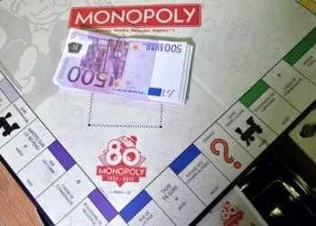500 euro banknotes are seen on a Monopoly boardgame as employees prepare envelopes with cash during a commercial operation of the Monopoly game, on January 13, 2015 in Saint-Avold, eastern France.