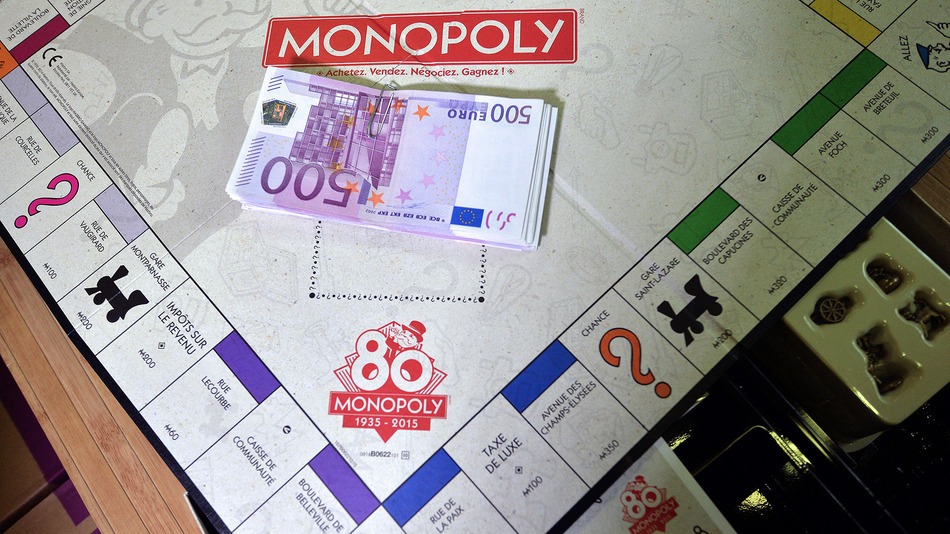 500 euro banknotes are seen on a Monopoly boardgame as employees prepare envelopes with cash during a commercial operation of the Monopoly game, on January 13, 2015 in Saint-Avold, eastern France.