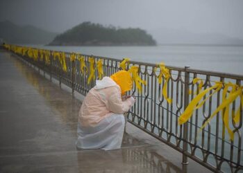 A relative weeps before yellow ribbons at Jindo harbour where family members of the Sewol ferry waited for developments in the search in 2014 (Source: news.com.au)