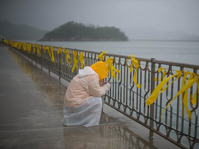 A relative weeps before yellow ribbons at Jindo harbour where family members of the Sewol ferry waited for developments in the search in 2014 (Source: news.com.au)