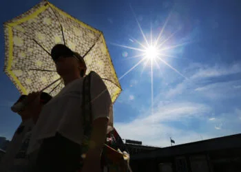 A man walks along the Tsim Sha Tsui public pier during sunset. The Hong Kong Observatory posted a warning for very hot weather with a maximum temperature of around 33 degrees, and also The Standby Signal, No. 1 is in force. 12AUG13
