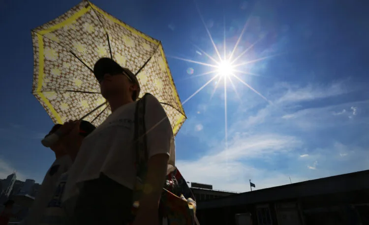 A man walks along the Tsim Sha Tsui public pier during sunset. The Hong Kong Observatory posted a warning for very hot weather with a maximum temperature of around 33 degrees, and also The Standby Signal, No. 1 is in force. 12AUG13