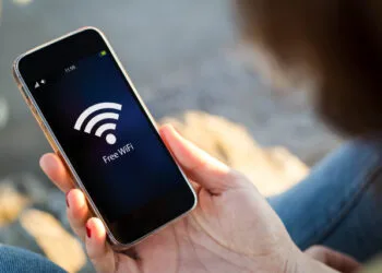 close-up view of young woman with free wifi on screen. All screen graphics are made up.