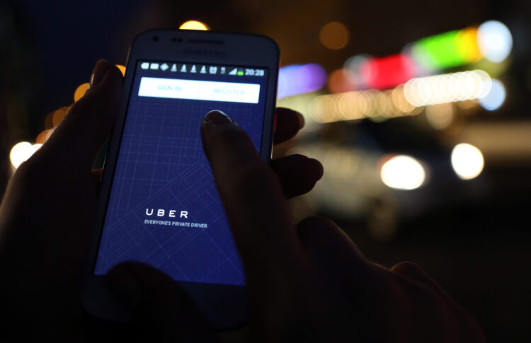 BERLIN, GERMANY - SEPTEMBER 02: In this photo illustration, a woman uses the Uber app on an Samsung smartphone on September 2, 2014 in Berlin, Germany. Uber, an app that allows passenger to buy rides from drivers who do not have taxi permits, has had its UberPop freelance driver service banned in Germany after a complaint by Taxi Deutschland, a trade association of taxi drivers in the country. The company, which operates in 42 countries over 200 cities worldwide, plans to both appeal the decision made by a court in Frankfurt as well as, at the risk of heavy fines, continue its services in Germany until a final decision has been made on the matter. (Photo by Adam Berry/Getty Images)